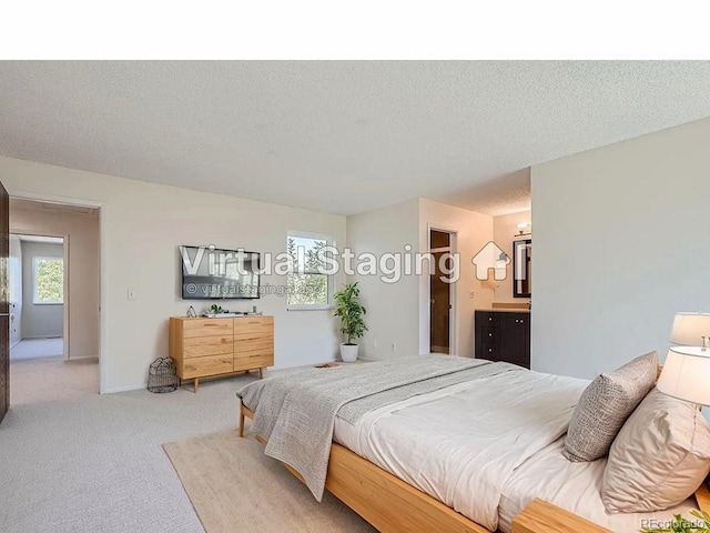 carpeted bedroom with connected bathroom and a textured ceiling