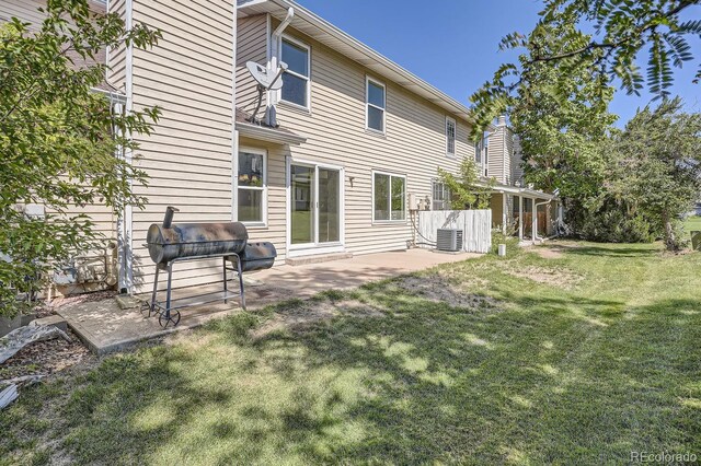 back of house with cooling unit, a yard, and a patio