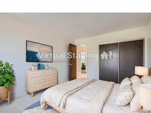 bedroom with a closet, light colored carpet, and a textured ceiling