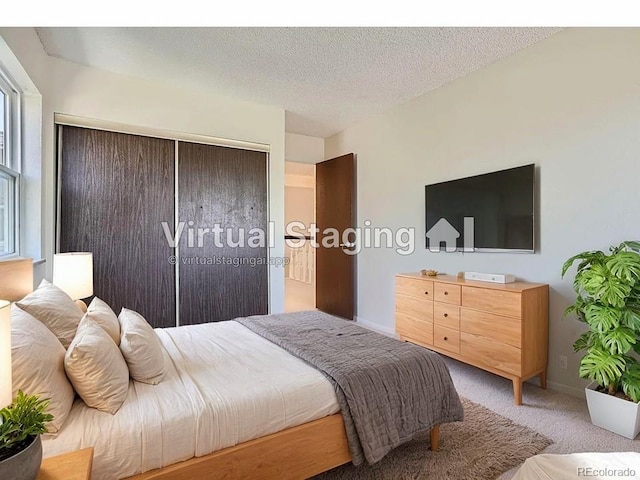 bedroom featuring carpet floors, a textured ceiling, and a closet