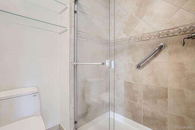 bathroom featuring toilet and an enclosed shower