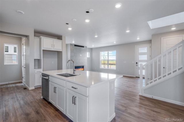 kitchen featuring white cabinetry, sink, dishwasher, and a kitchen island with sink