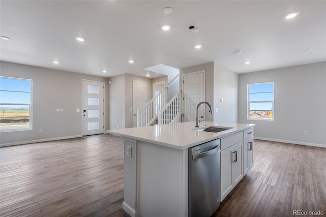 kitchen featuring sink, plenty of natural light, white cabinets, a center island with sink, and stainless steel dishwasher