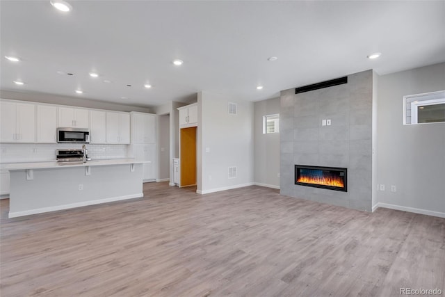 unfurnished living room featuring a fireplace and light hardwood / wood-style flooring