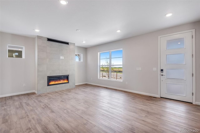 unfurnished living room featuring a fireplace and light wood-type flooring