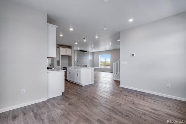 kitchen with sink, white cabinetry, a center island with sink, dishwasher, and hardwood / wood-style floors