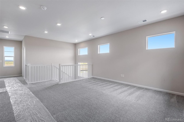 spare room featuring light colored carpet and plenty of natural light