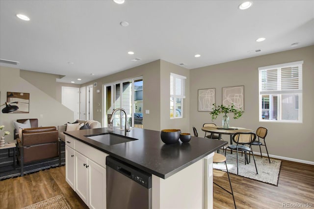 kitchen featuring sink, stainless steel dishwasher, an island with sink, and white cabinets