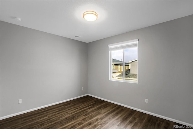 unfurnished room with dark hardwood / wood-style flooring