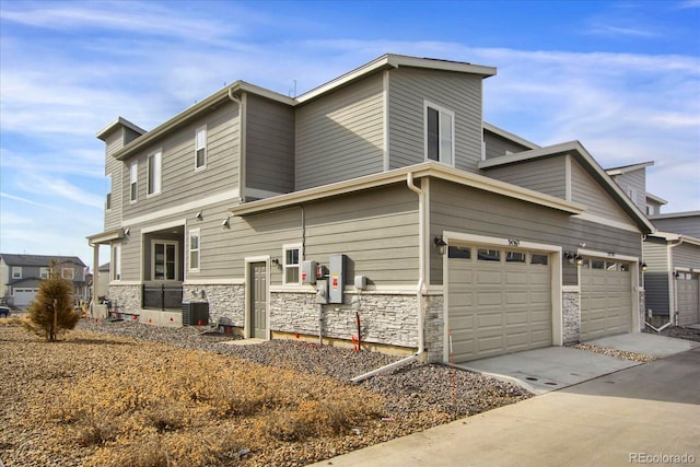 view of side of home with a garage and cooling unit