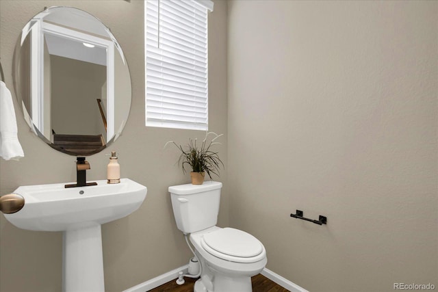 bathroom with hardwood / wood-style flooring and toilet