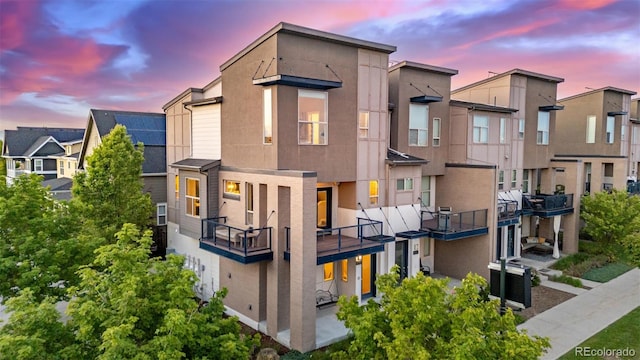 10305 Martin Luther King Blvd, Denver, CO 80238 - back of property at dusk with a balcony, stucco siding, and a residential view