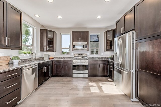 10305 Martin Luther King Blvd, Denver, CO 80238 - kitchen with appliances with stainless steel finishes, a sink, light stone counters, dark brown cabinets, and recessed lighting