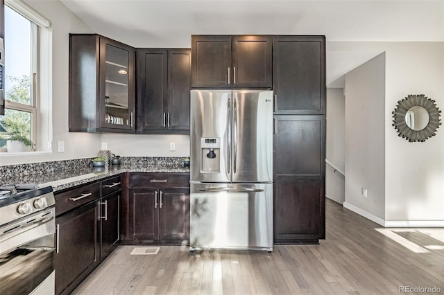 10305 Martin Luther King Blvd, Denver, CO 80238 - kitchen with stainless steel appliances, light wood-style flooring, stone countertops, glass insert cabinets, and dark brown cabinetry