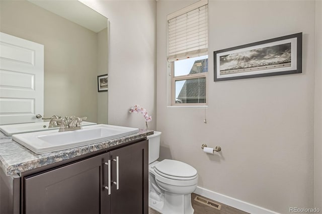 10305 Martin Luther King Blvd, Denver, CO 80238 - half bath with baseboards, toilet, vanity, and wood finished floors