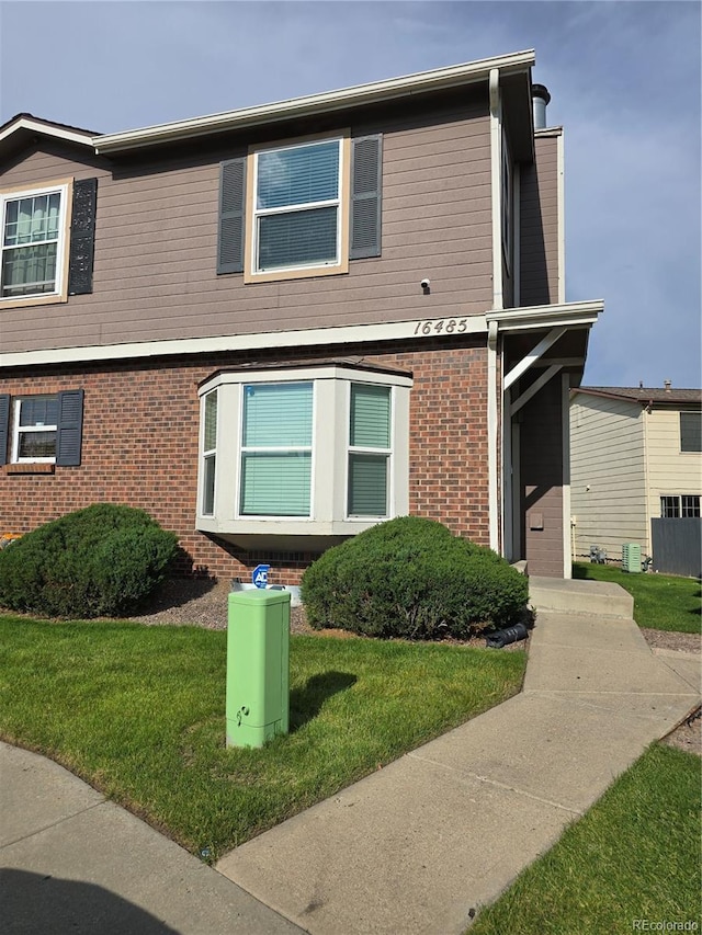 16485 E 17th Pl Unit D, Aurora, CO 80011 - view of front of house featuring brick siding and a front yard