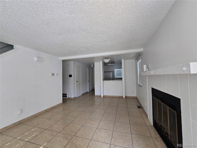 16485 E 17th Pl Unit D, Aurora, CO 80011 - unfurnished living room with a textured ceiling, a fireplace, and light tile patterned floors