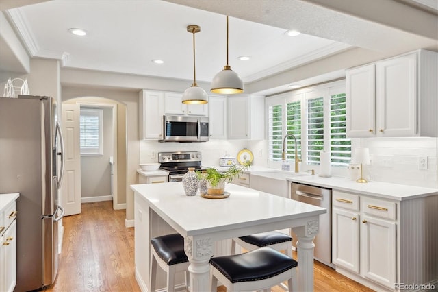 1449 Braewood Ave, Highlands Ranch, CO 80129 - kitchen with stainless steel appliances, a sink, arched walkways, ornamental molding, and a breakfast bar area