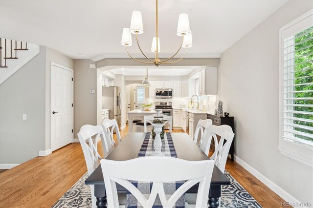 1449 Braewood Ave, Highlands Ranch, CO 80129 - dining space with light wood-style flooring, plenty of natural light, baseboards, and arched walkways