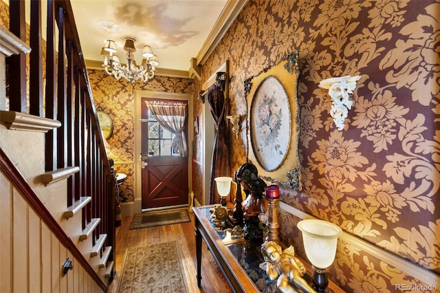 310 E Whiting Ave, Cripple Creek, CO 80813 - foyer with wallpapered walls, crown molding, hardwood / wood-style flooring, and a chandelier