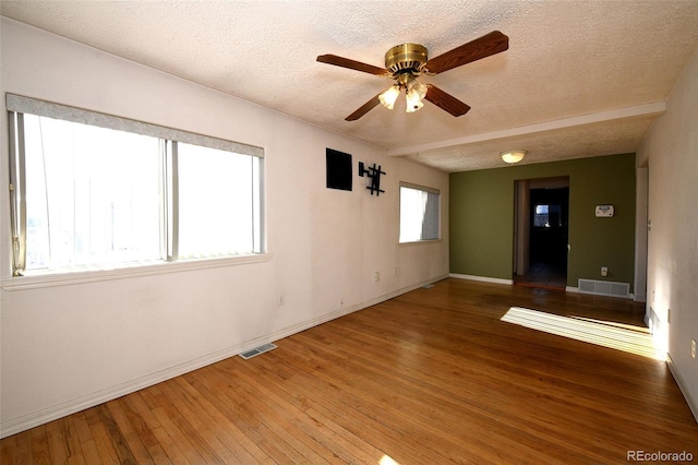 spare room featuring ceiling fan, hardwood / wood-style floors, and a textured ceiling