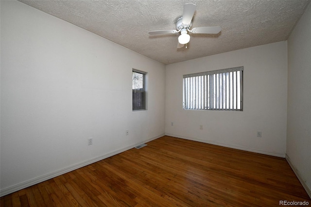 spare room with ceiling fan, dark wood-type flooring, and a textured ceiling