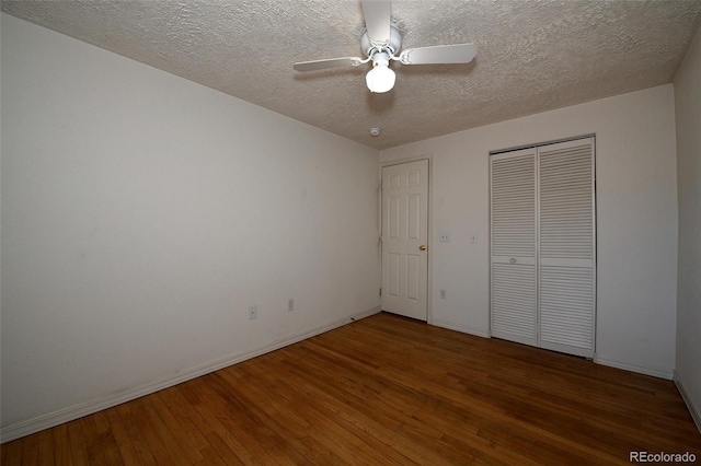 unfurnished bedroom with ceiling fan, a closet, a textured ceiling, and hardwood / wood-style flooring