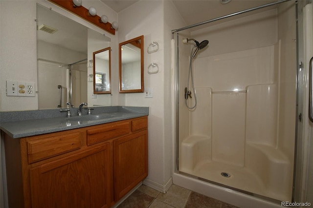 bathroom featuring tile patterned floors, vanity, and walk in shower