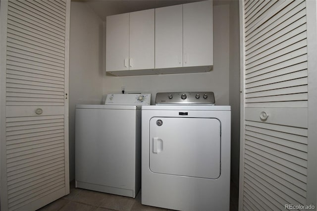 laundry area featuring cabinets, light tile patterned floors, and washer and dryer