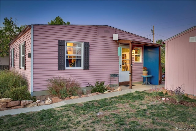 view of front of home featuring a storage unit and a front yard