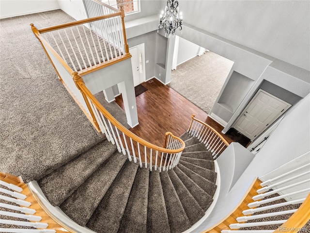 stairway with hardwood / wood-style flooring and a chandelier