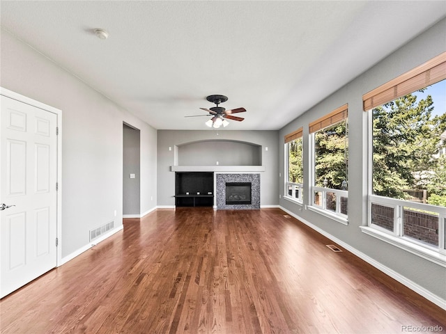 unfurnished living room featuring wood-type flooring and ceiling fan