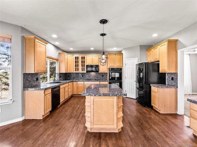 kitchen with decorative light fixtures, a center island, light brown cabinets, and black appliances