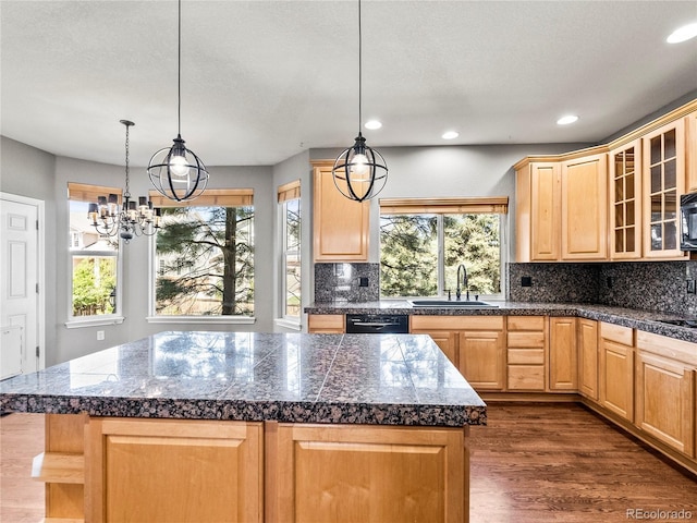 kitchen featuring decorative light fixtures, sink, a kitchen island, and light brown cabinets