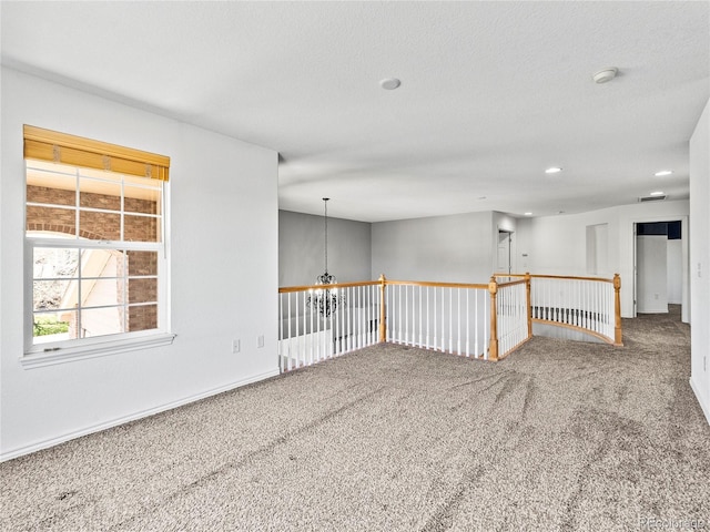 unfurnished room featuring a textured ceiling and carpet