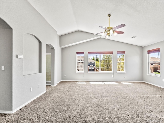 carpeted spare room featuring a textured ceiling, vaulted ceiling, and ceiling fan