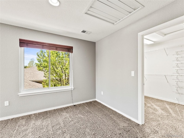 empty room with carpet flooring and a textured ceiling