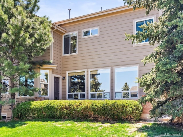 rear view of property featuring a lawn