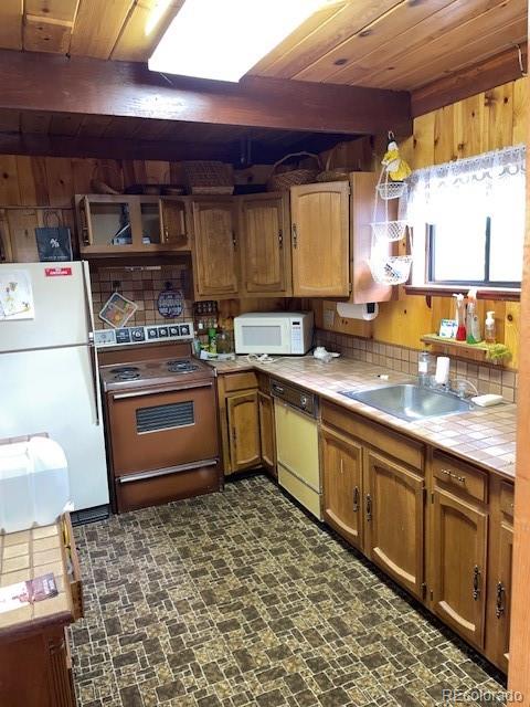 kitchen with sink, wood ceiling, tasteful backsplash, and white appliances