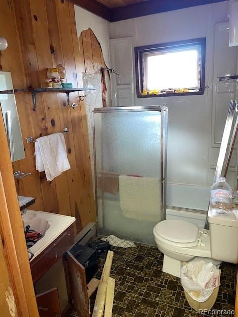 bathroom with tile patterned floors, wooden walls, walk in shower, and toilet