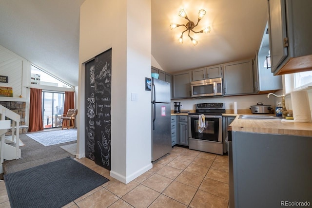 kitchen featuring appliances with stainless steel finishes, gray cabinetry, sink, wood counters, and light tile patterned flooring