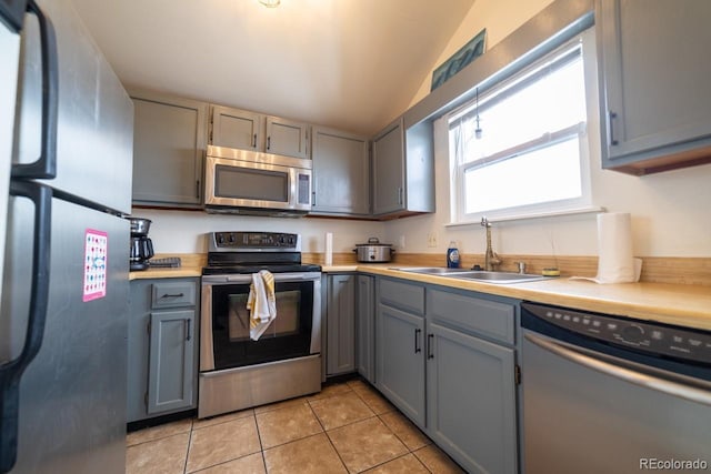 kitchen featuring sink, light tile patterned floors, gray cabinetry, and stainless steel appliances