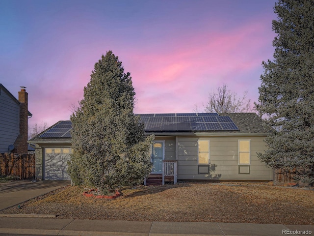 view of front of house featuring solar panels and a garage