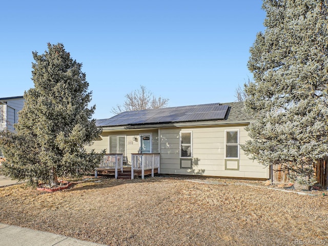 single story home featuring solar panels