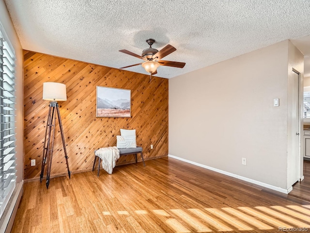 unfurnished room featuring ceiling fan, light hardwood / wood-style flooring, a wealth of natural light, and a textured ceiling