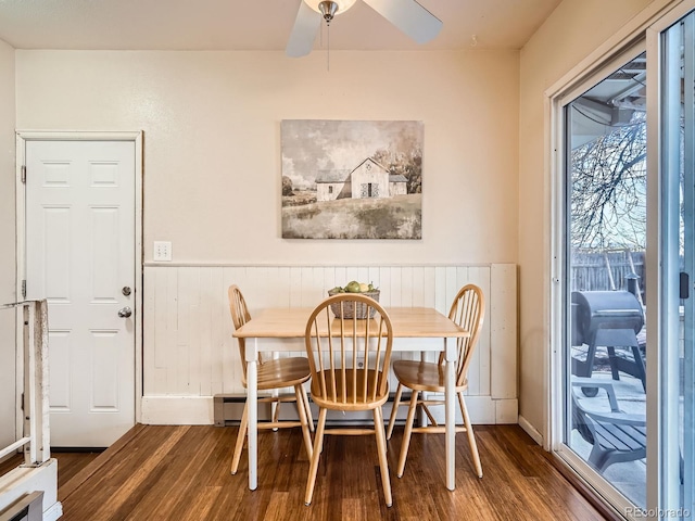 dining area with ceiling fan and dark wood-type flooring