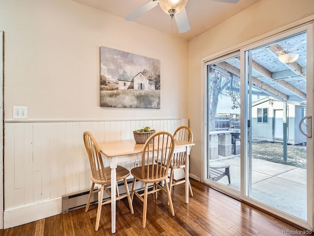 dining space featuring ceiling fan, a baseboard radiator, and wood-type flooring