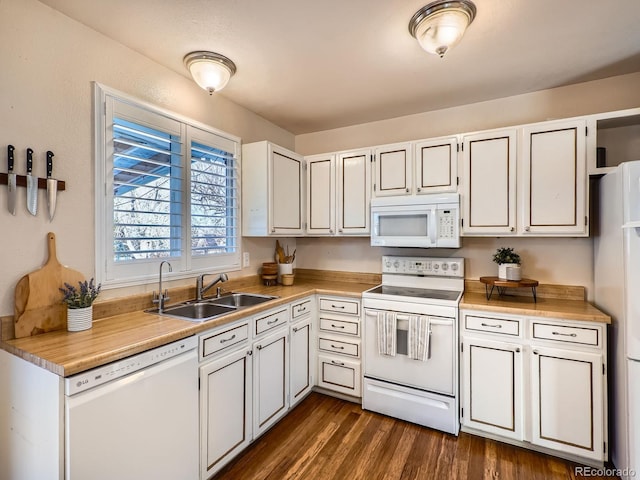 kitchen featuring sink, white appliances, white cabinets, and dark hardwood / wood-style floors