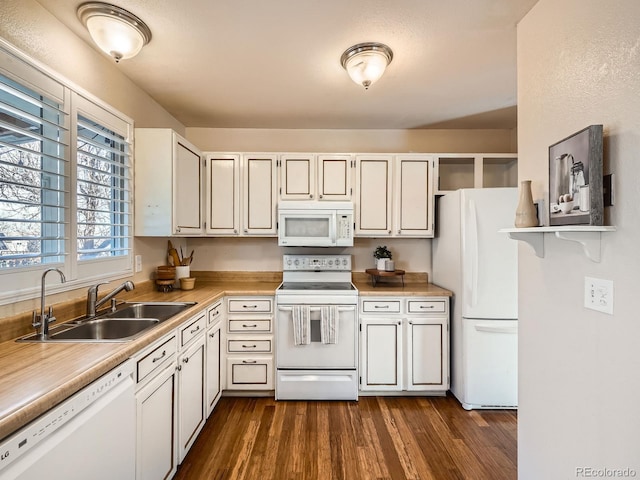 kitchen with white appliances, white cabinetry, dark hardwood / wood-style floors, and sink