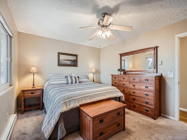 bedroom featuring a baseboard heating unit, light colored carpet, ceiling fan, and a textured ceiling